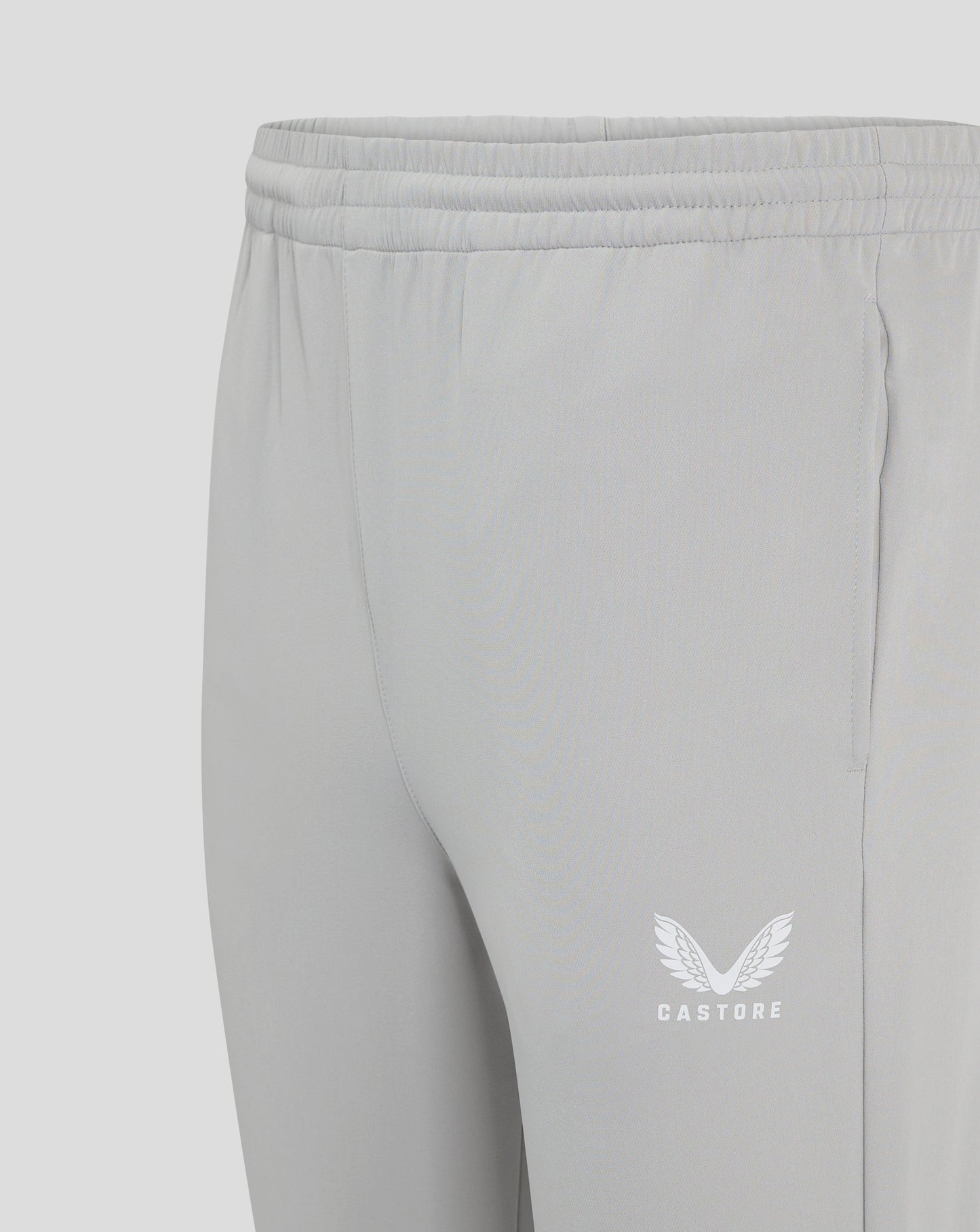 Close up of the elastic waistband with drawcord on light gray track pants