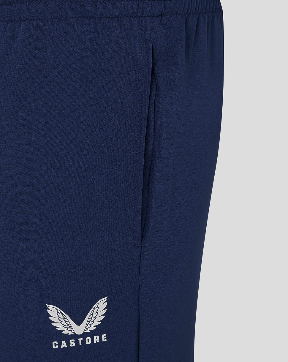 Close up of navy track pants highlighting side seam and Castore logo at the lower leg.