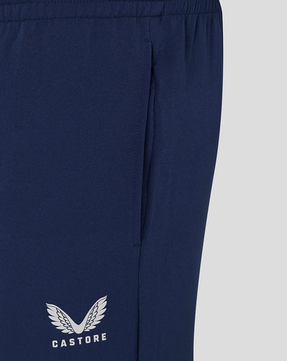 Close up of navy track pants highlighting side seam and Castore logo at the lower leg.