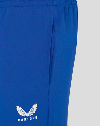 Close-up of royal blue track pants fabric with a white Castore logo featuring wings on the leg.