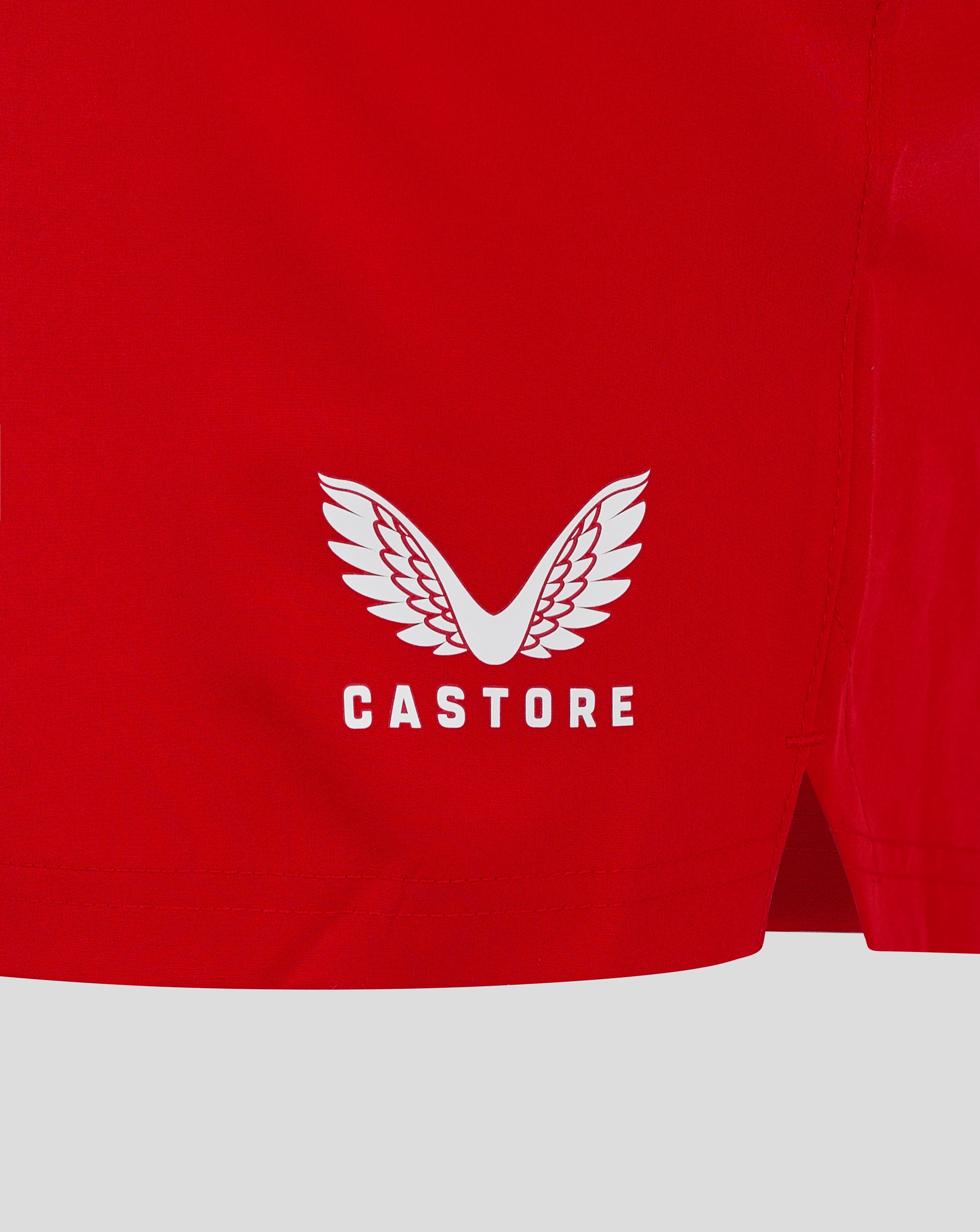 Back view of red shorts with white Castore wing logo near the hem.