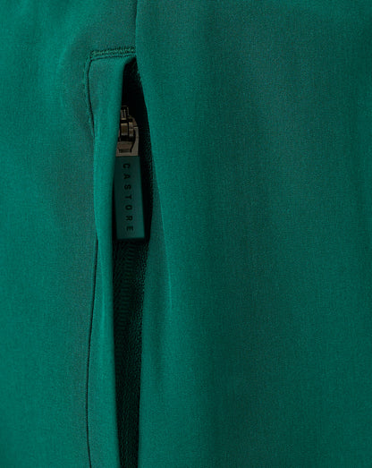 Close-up of teal woven fabric with a vertical zip and Castore branded zipper pull