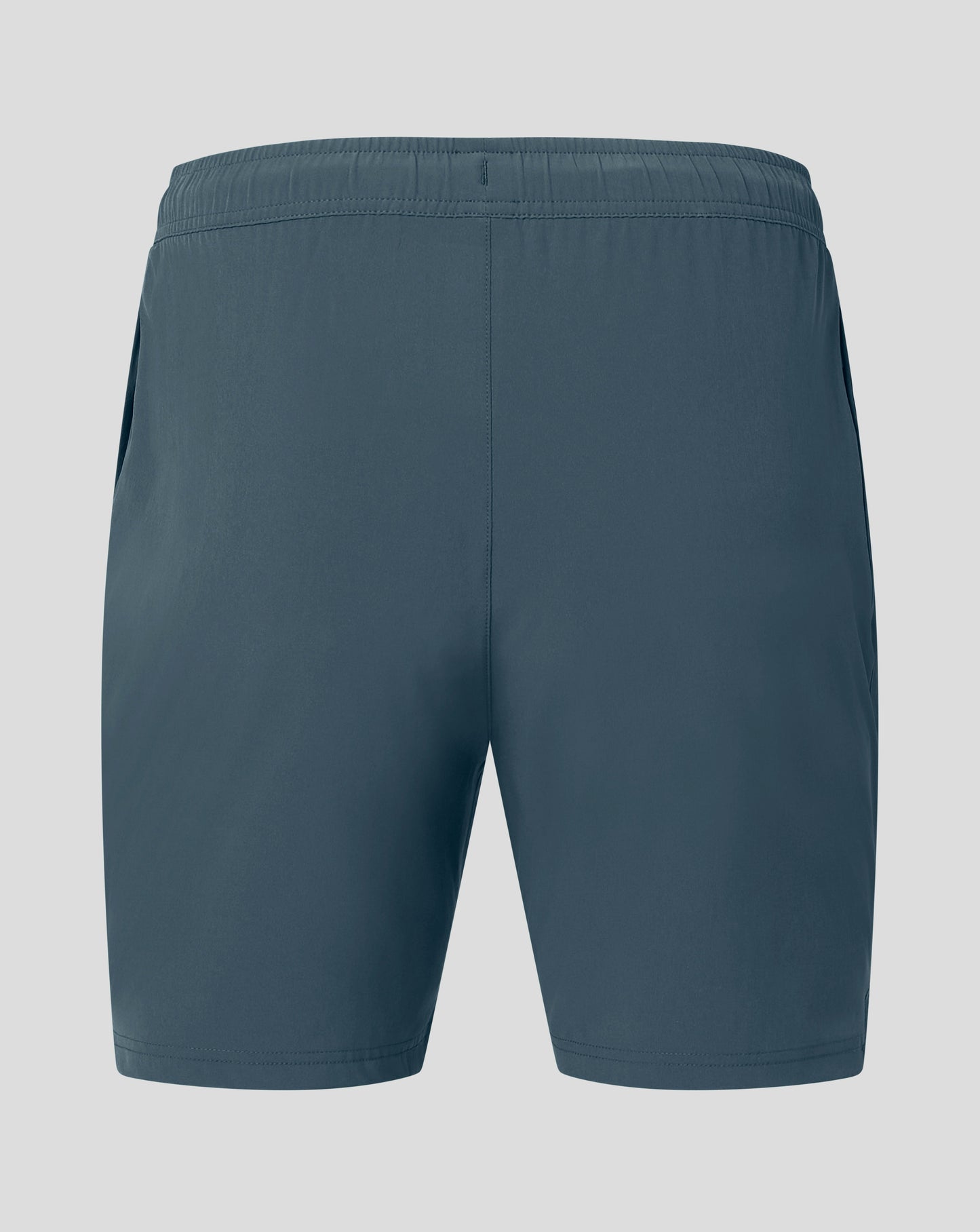 Back view of dark slate woven training shorts with elastic waistband and Castore logo on the hem