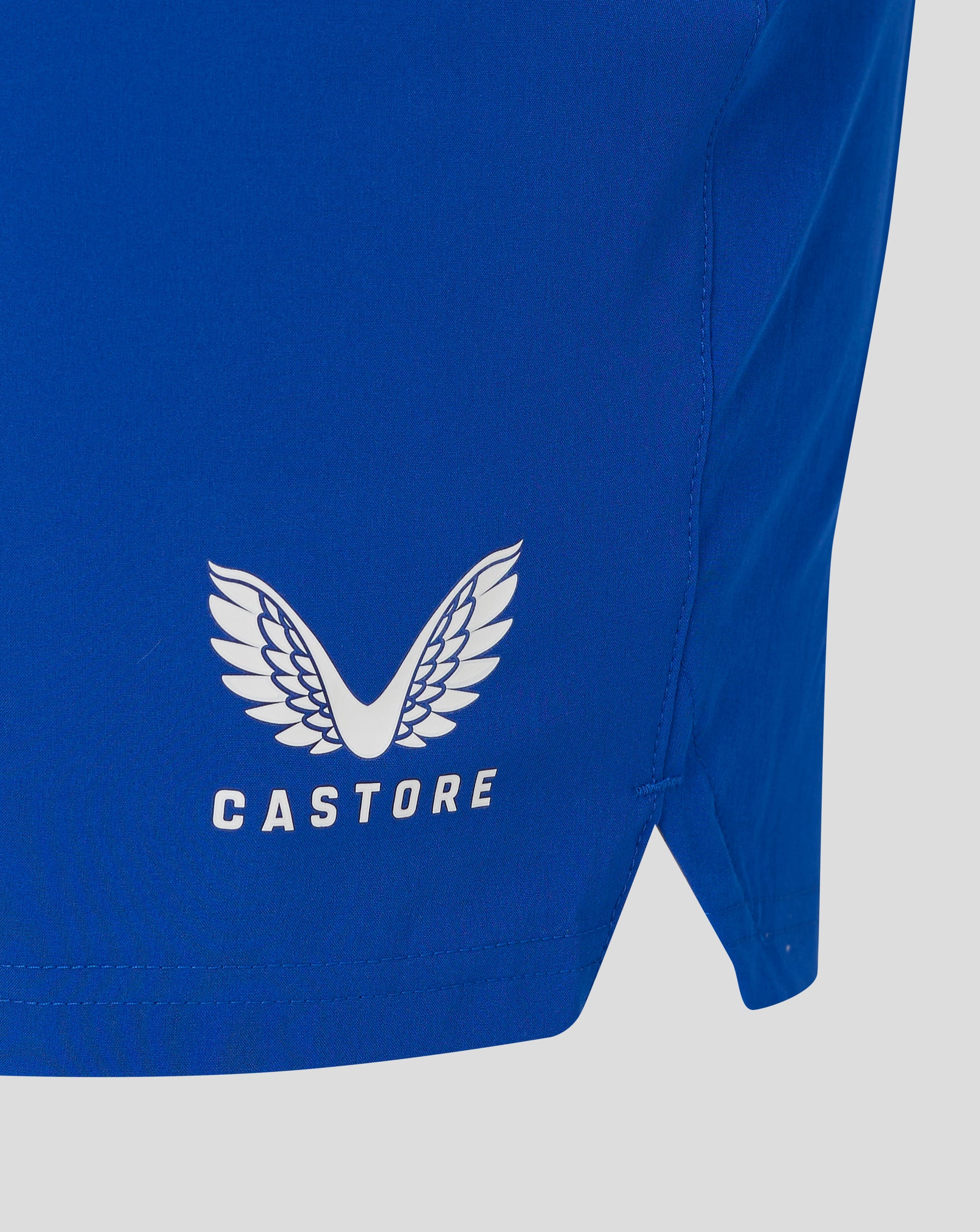 Blue woven training shorts with a white Castore wing logo visible on the fabric