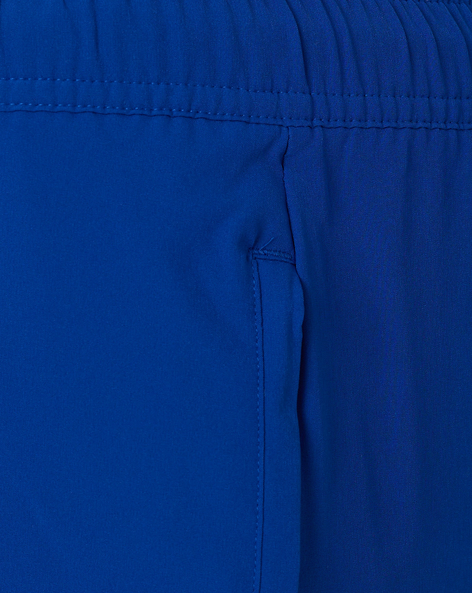 Close up of blue waistband area on woven shorts with stitching and gathered fabric