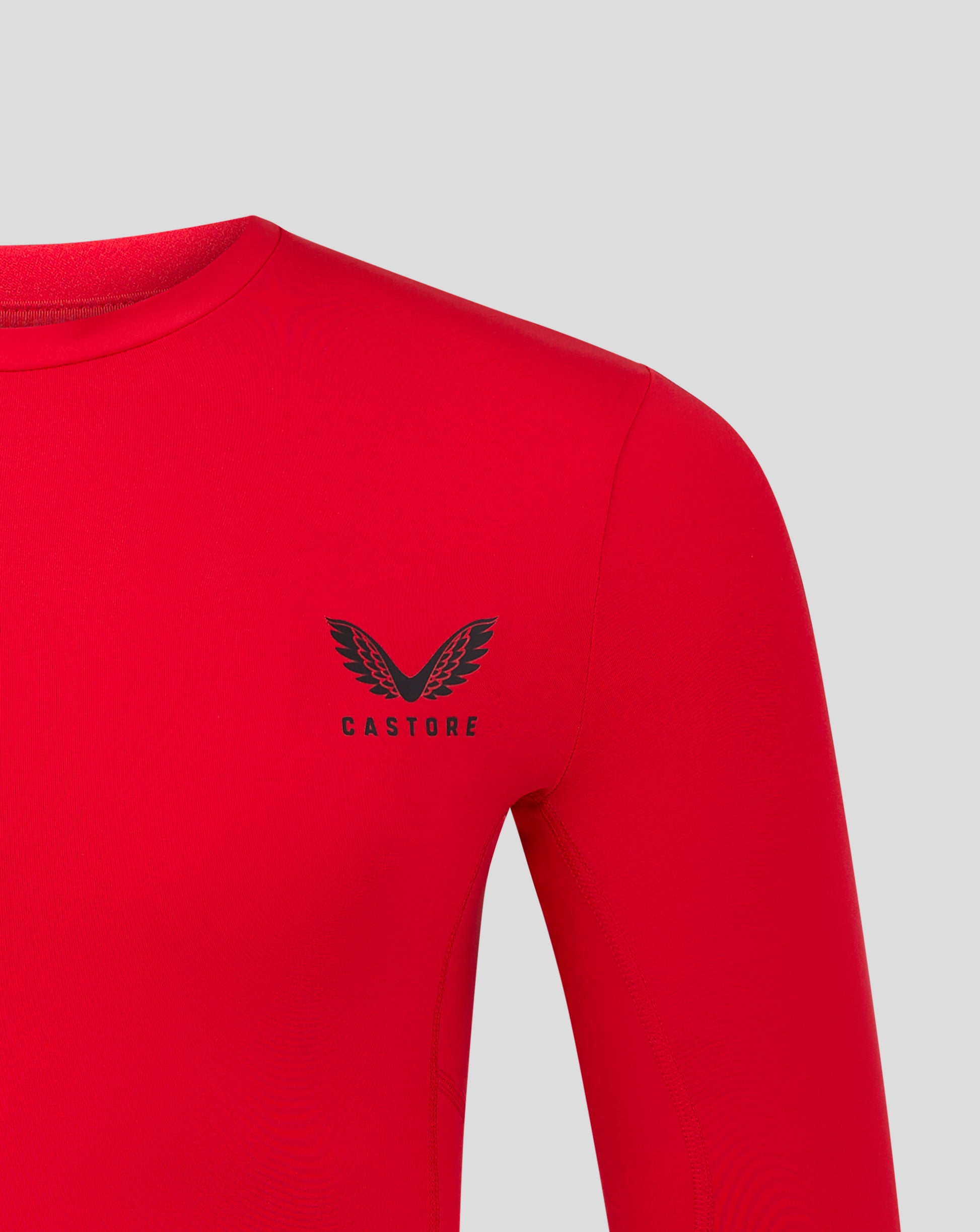 Shoulder and upper chest area of red baselayer with black Castore logo