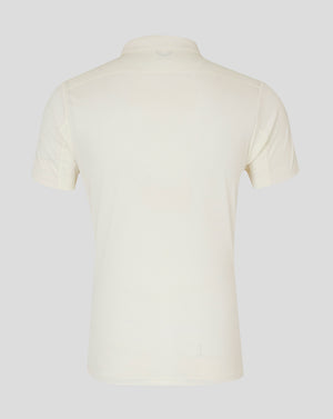 Back view of cream cricket polo showing a clean silhouette and neck logo.