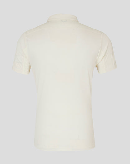 Back view of cream cricket polo showing a clean silhouette and neck logo.