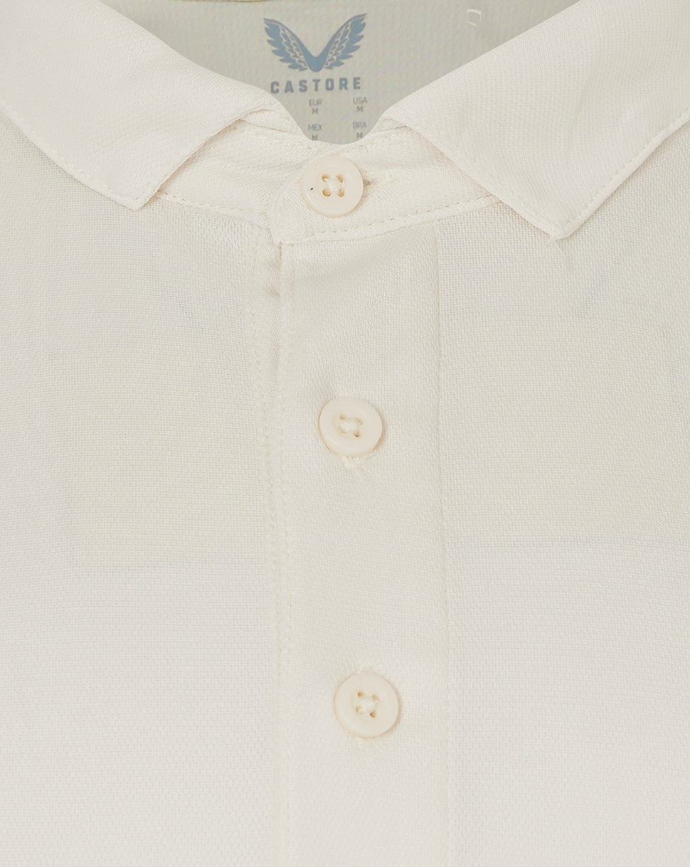 Close up of collar and button placket on cream polo showing textured fabric.