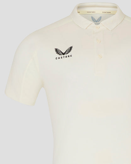 Cream mens cricket polo with winged Castore logo on chest and subtle collar detail