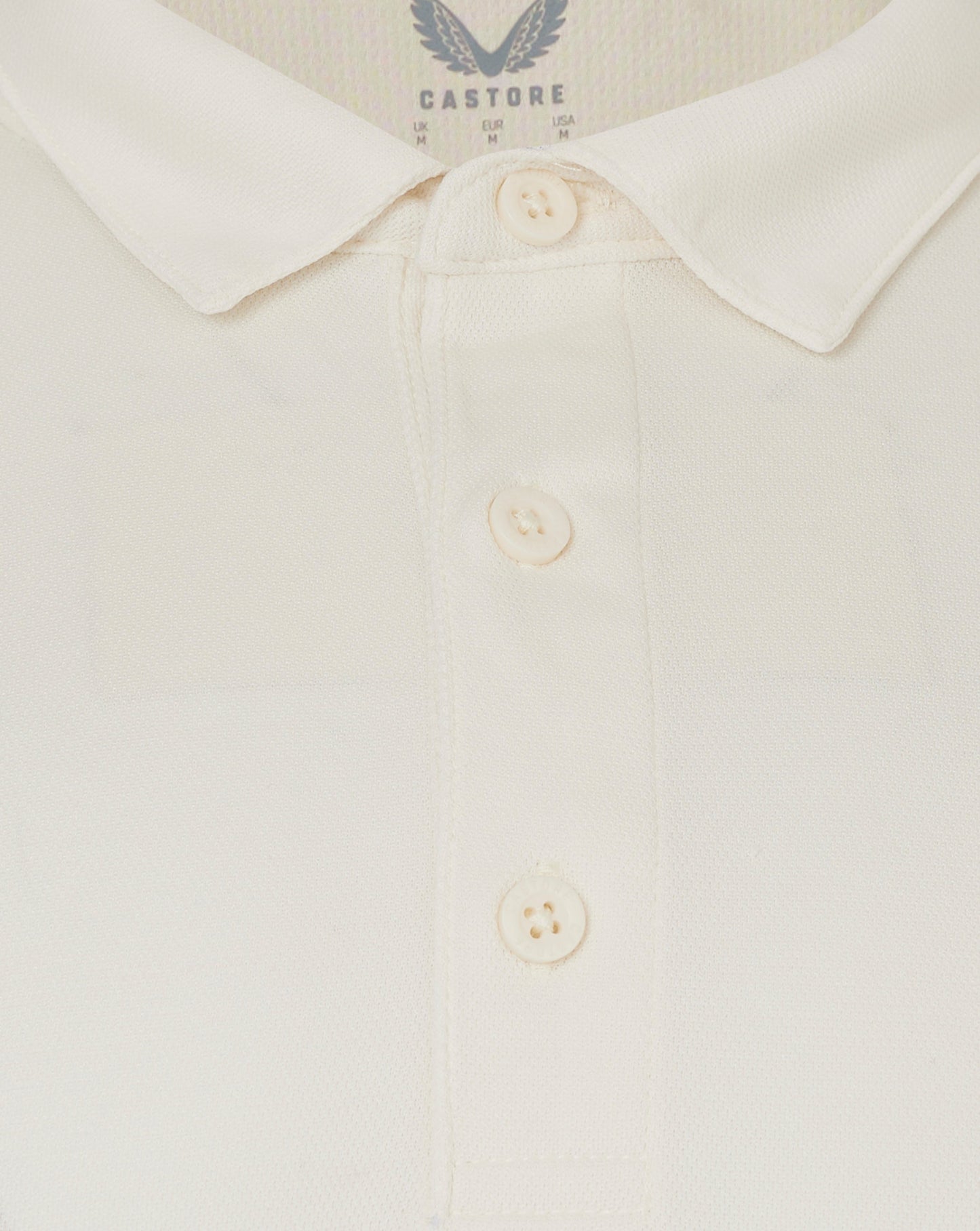 Close up of Cannoli Cream long sleeve cricket shirt collar with button placket and heat sealed Castore logo
