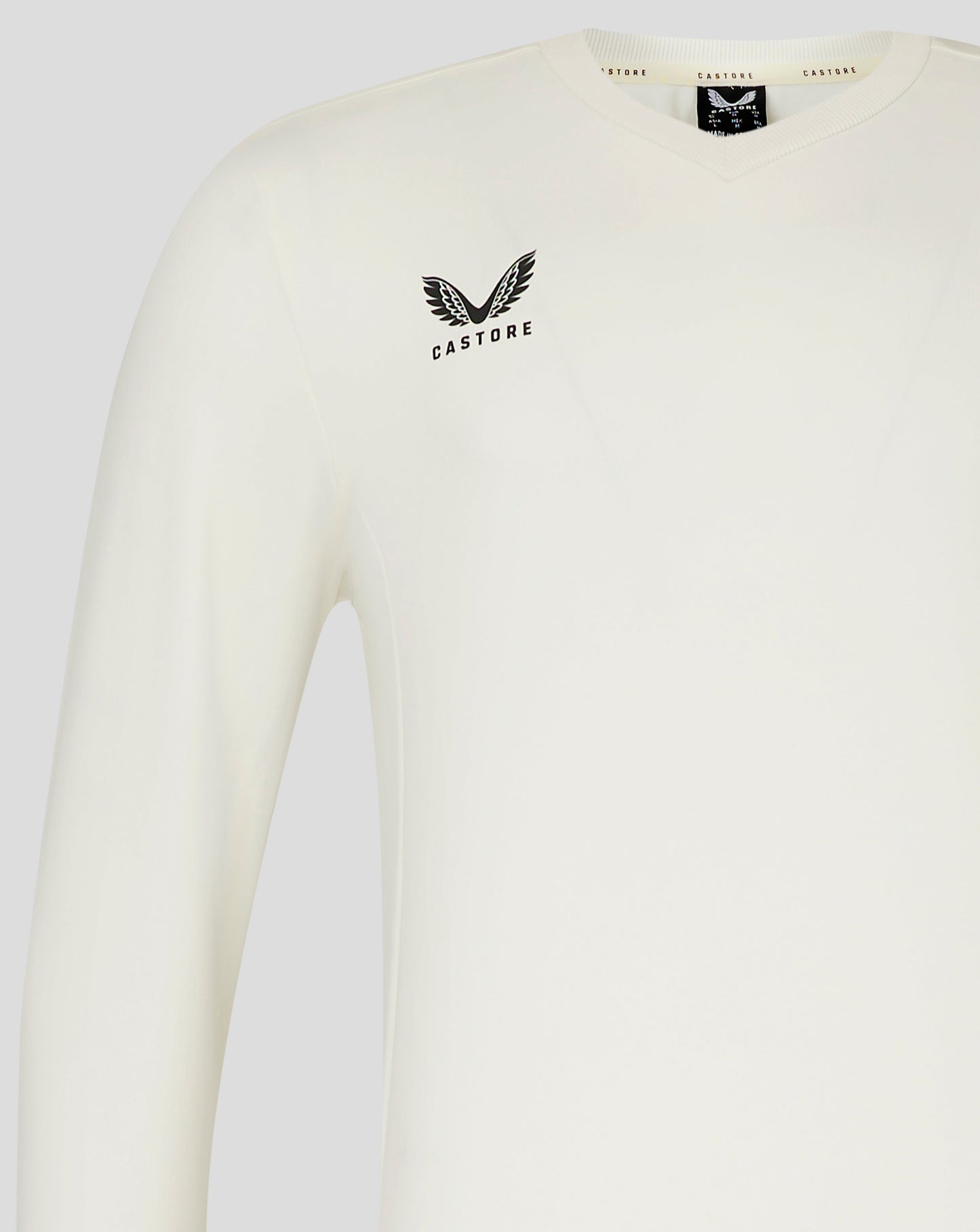 Left chest view of Cannoli Cream cricket jumper with Castore logo and neck label visible.
