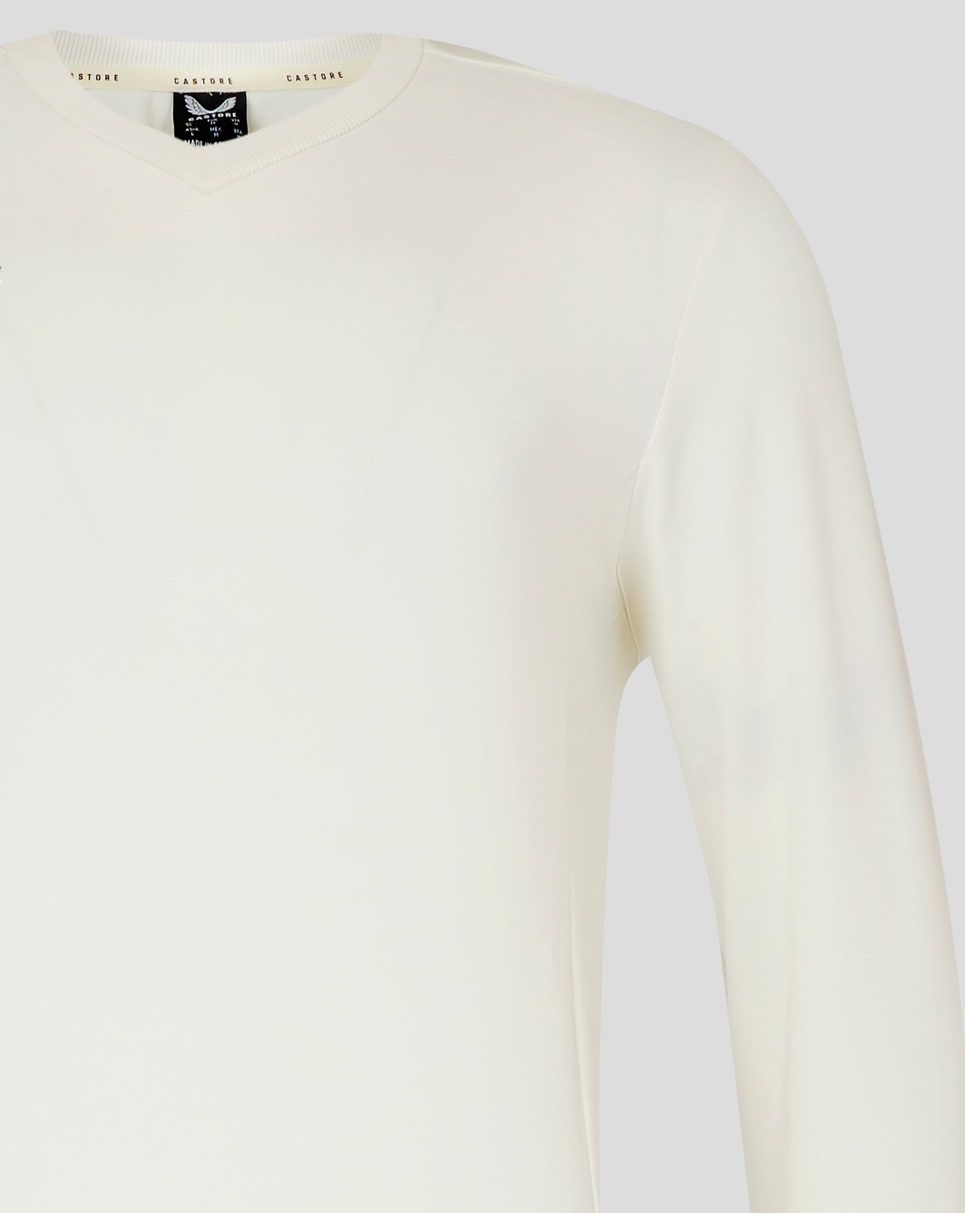 Upper chest and shoulder area of Cannoli Cream cricket jumper in plain knit fabric.