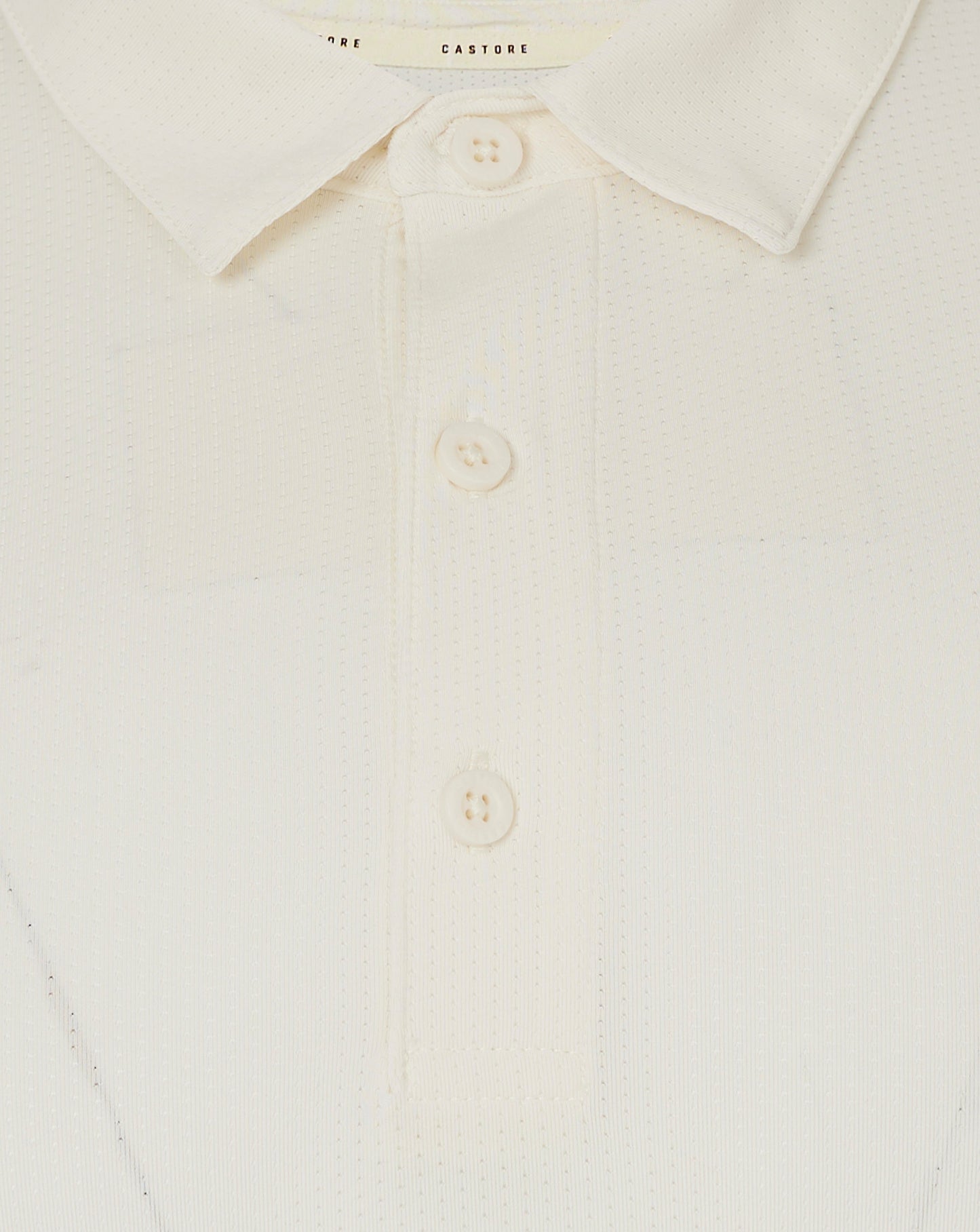 Close up of collar and three button placket on Cannoli Cream Castore cricket shirt