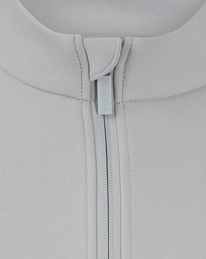 Close-up of back neck area showing Castore branded zipper pull on a light gray fleece jacket