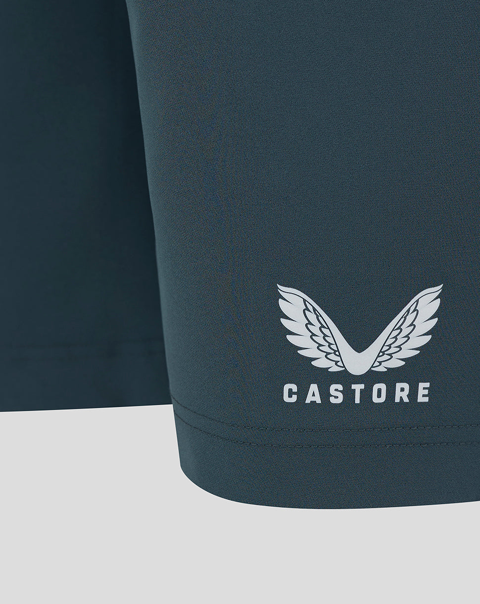 Close-up of dark slate fabric with Castore logo near the hem.