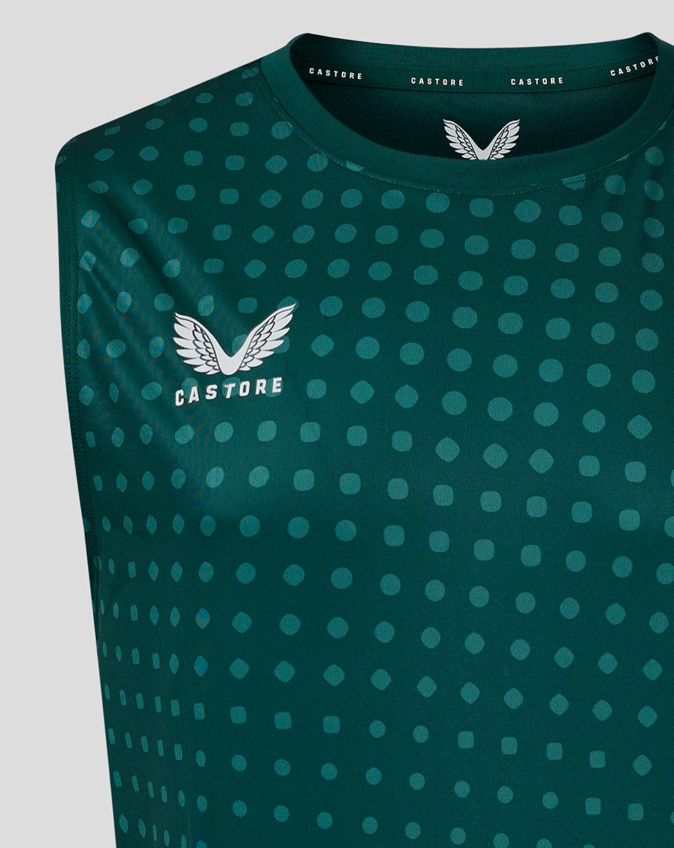 Close-up of teal singlet showing dot pattern and Castore logo on left chest near collar