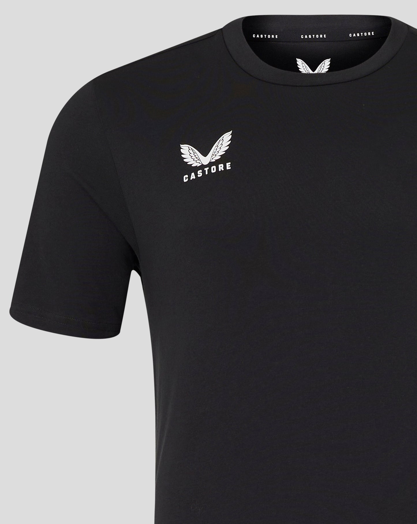 Close up of front left chest white wing Castore logo on black tee.