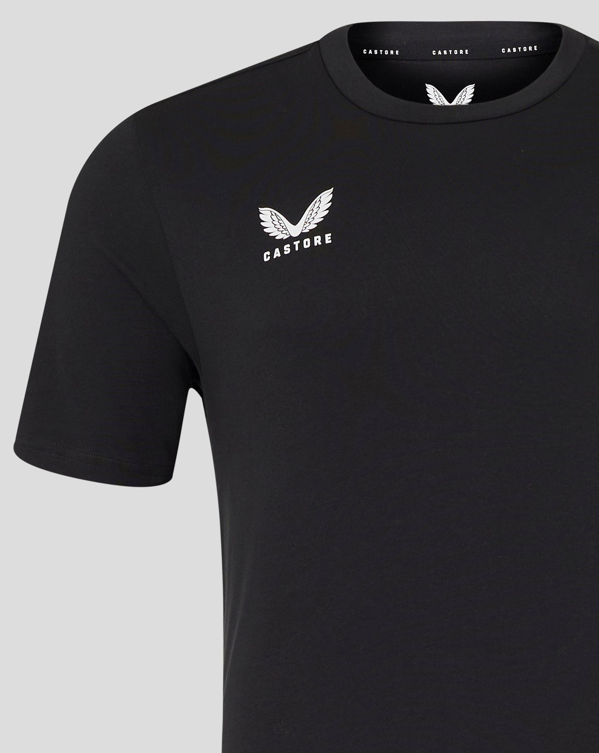 Close up of front left chest white wing Castore logo on black tee.