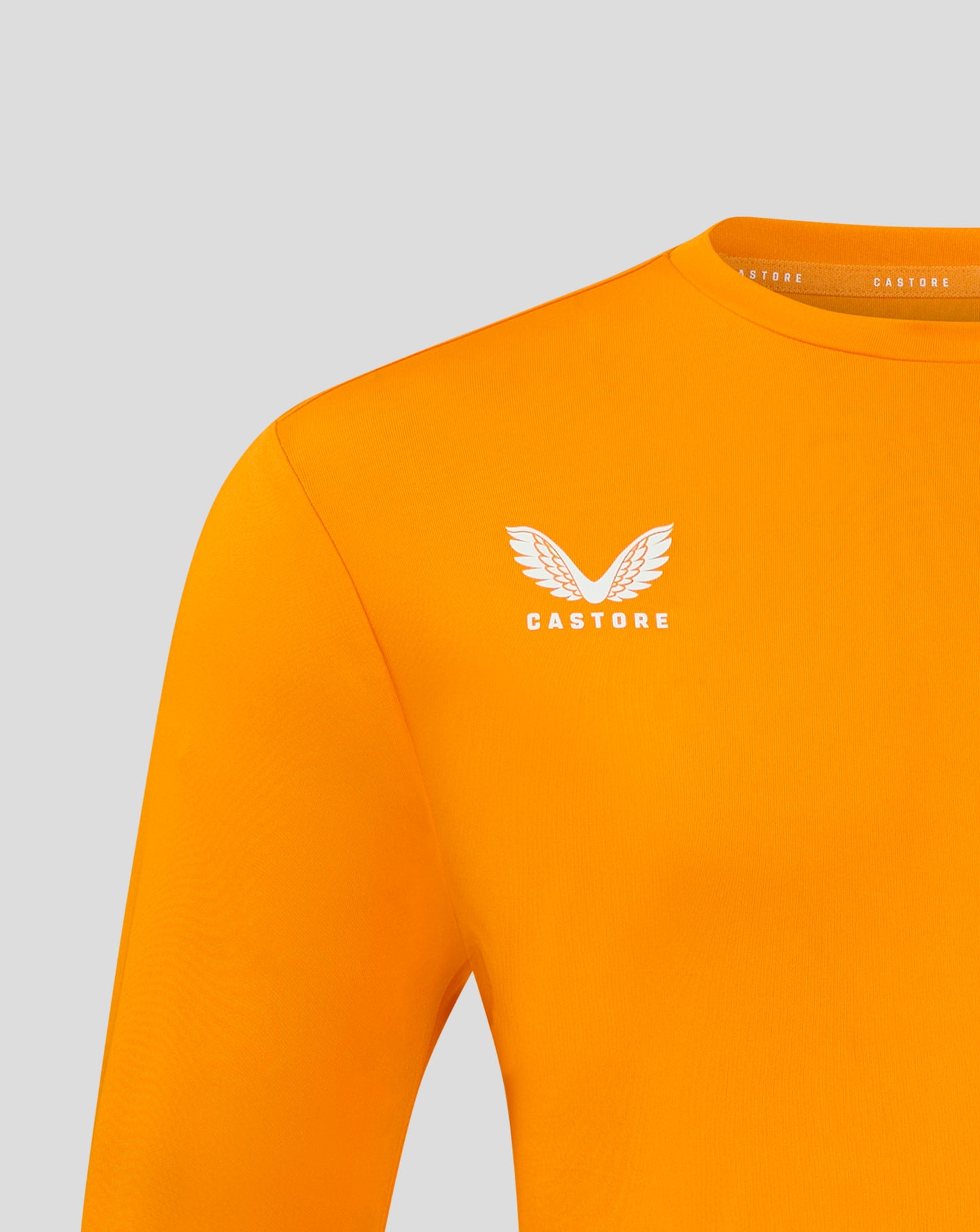 Bright marigold long sleeve tee with crew neck and white Castore wing logo on chest.