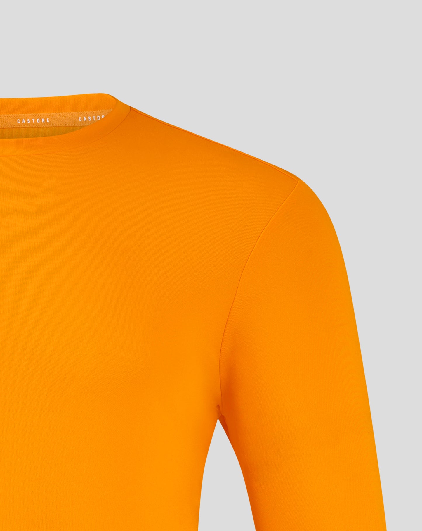 Close-up of bright marigold tee neckline with Castore branding on the inner collar.