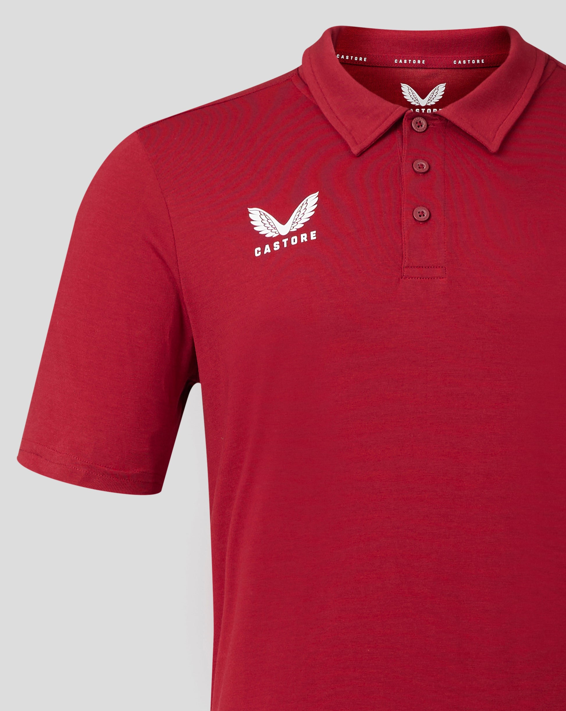 Front view of red polo with white Castore logo on the left chest and a three button placket.