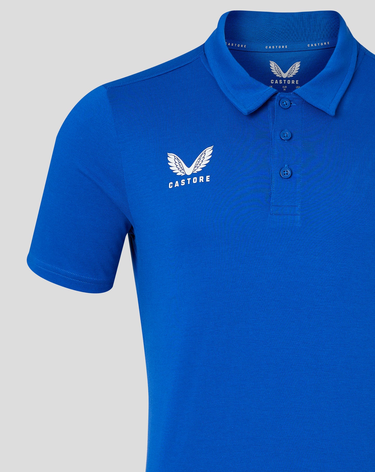 Bright blue polo with self fabric collar and white Castore logo on the left chest