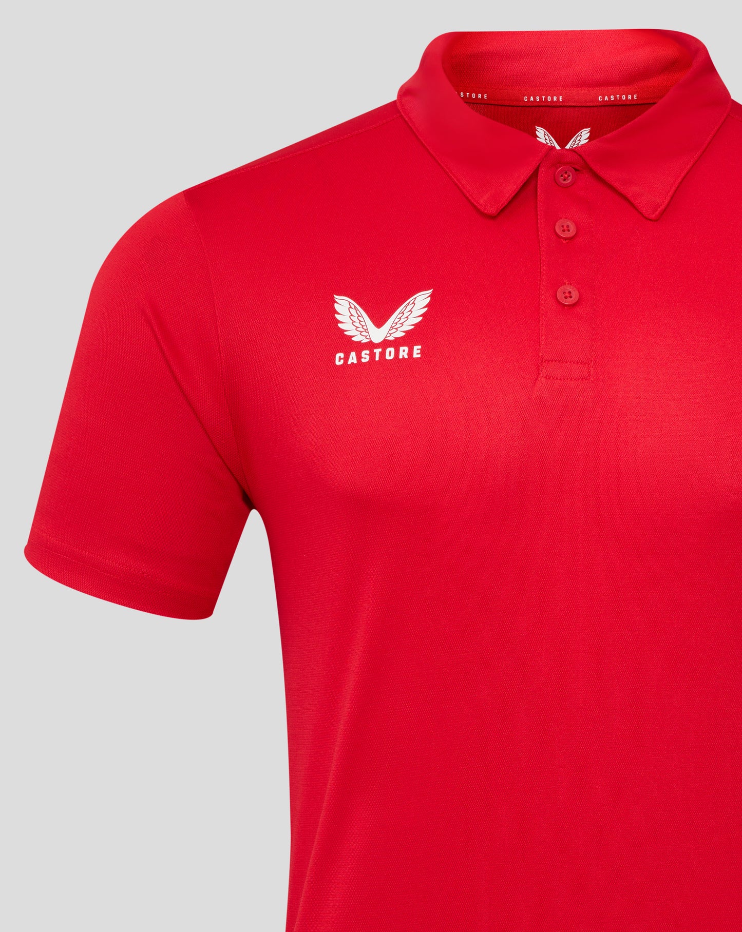Red men's performance polo with self fabric collar three button placket and white Castore wing logo on the left chest.