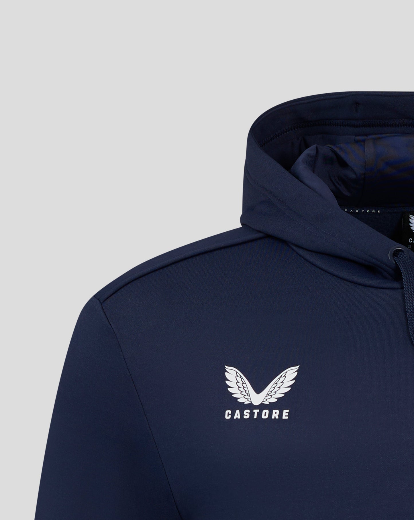 Close-up of navy Peacoat men's performance overhead hoodie with white winged Castore logo on the chest.