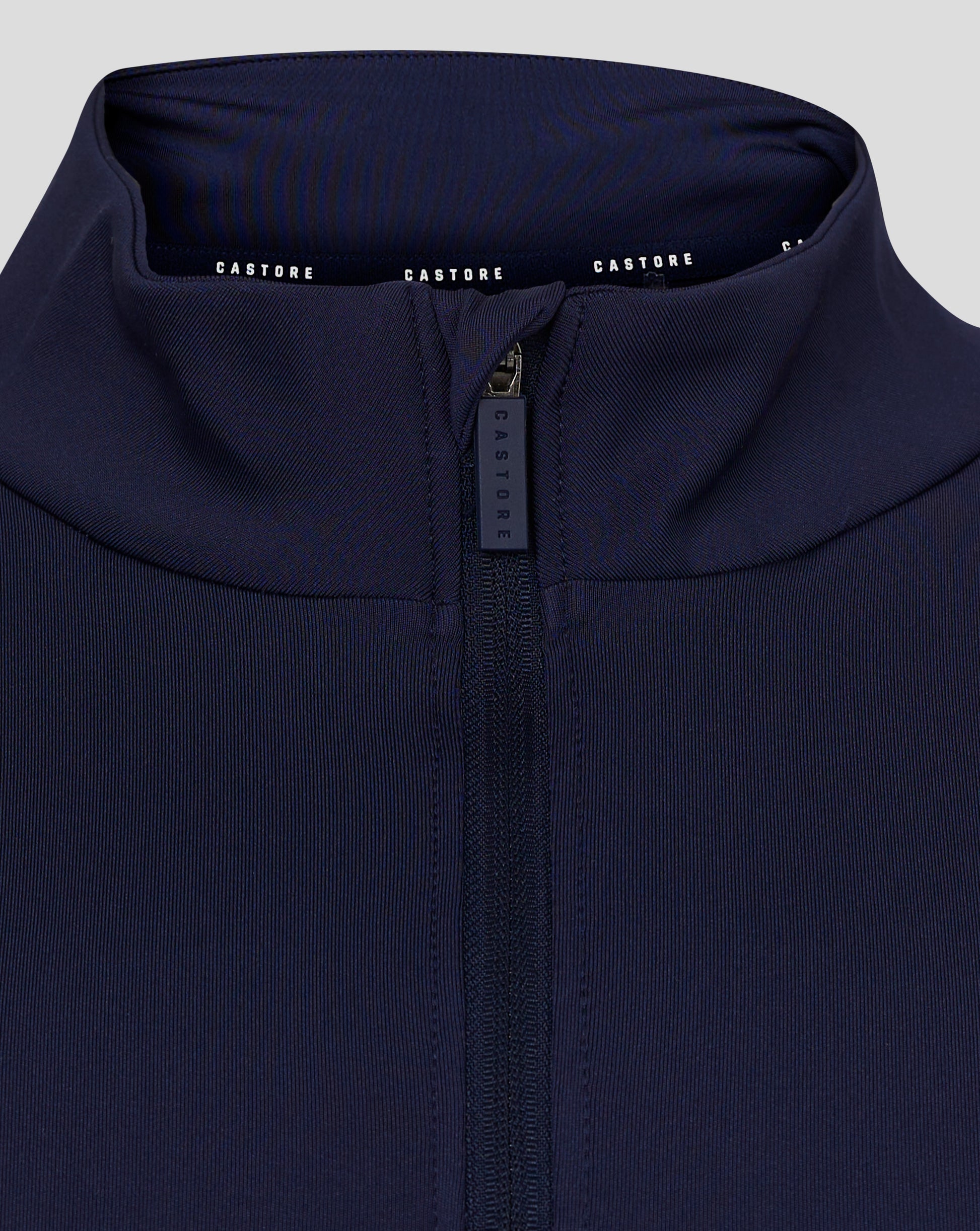 Rear view of navy quarter zip top with folded collar and Castore branding along the inner neckline