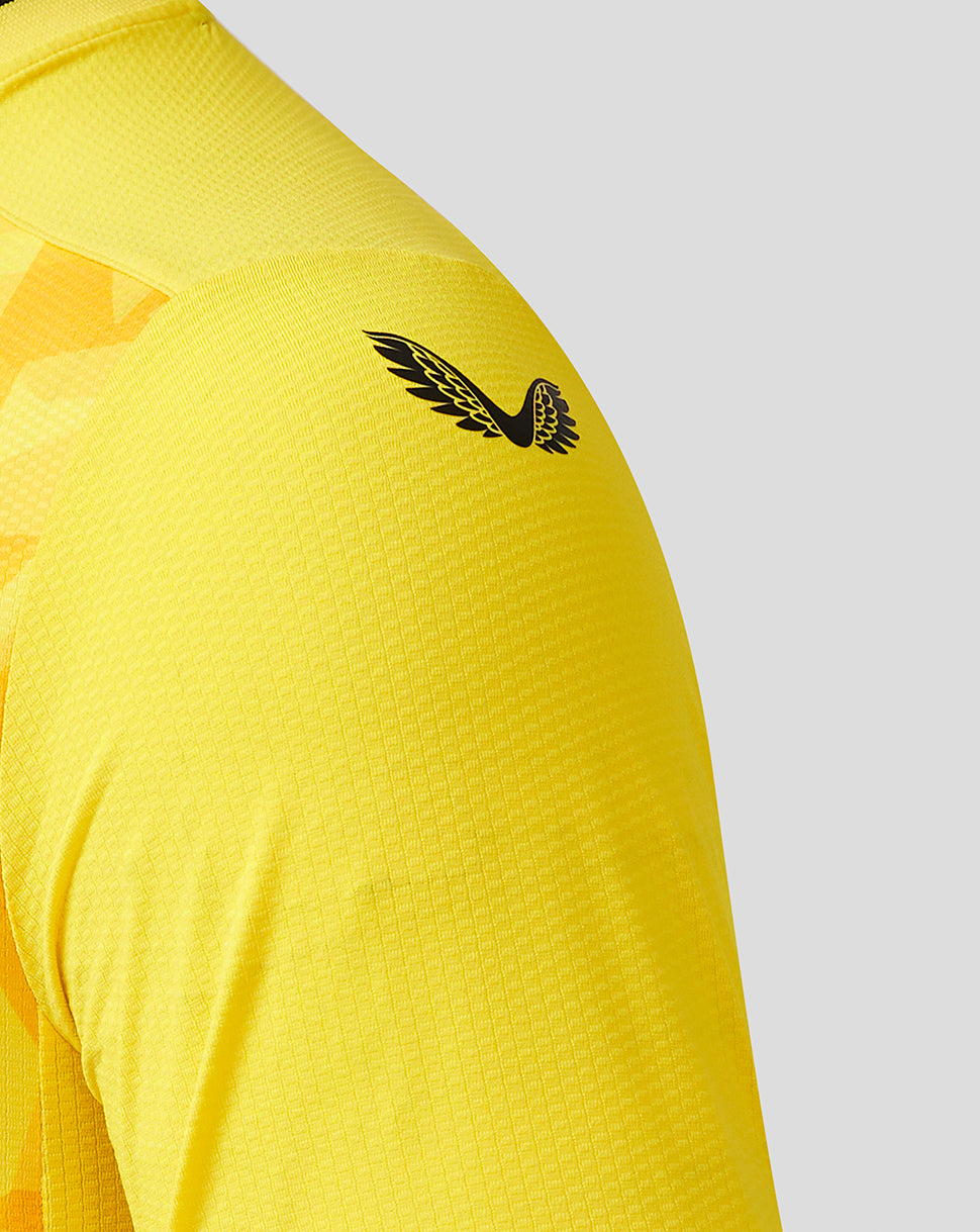 Shoulder close-up of the yellow Wolves Pro Third Goalkeeper shirt featuring a black winged crest on the sleeve