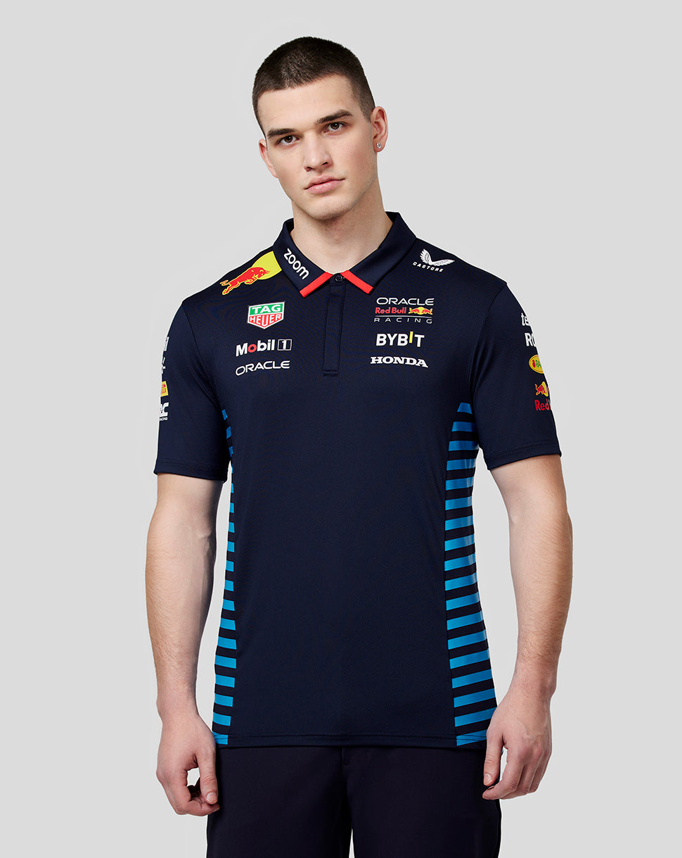 Front view of a man in a night sky Oracle Red Bull Racing teamline polo with sponsor logos and blue side panels.