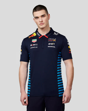 Front view of a man in a night sky Oracle Red Bull Racing teamline polo with sponsor logos and blue side panels.