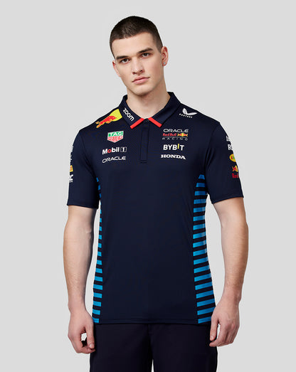 Front view of a man in a night sky Oracle Red Bull Racing teamline polo with sponsor logos and blue side panels.