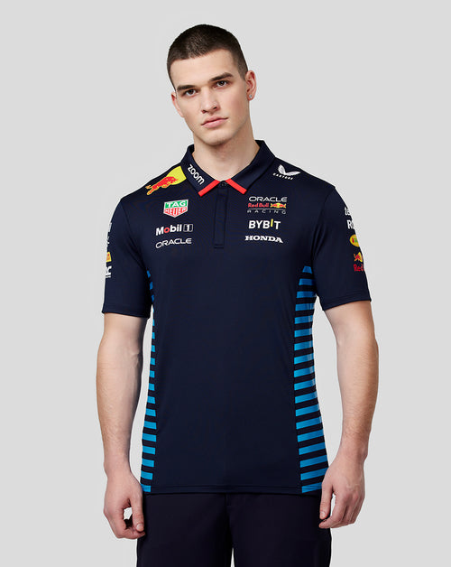 Front view of a man in a night sky Oracle Red Bull Racing teamline polo with sponsor logos and blue side panels.