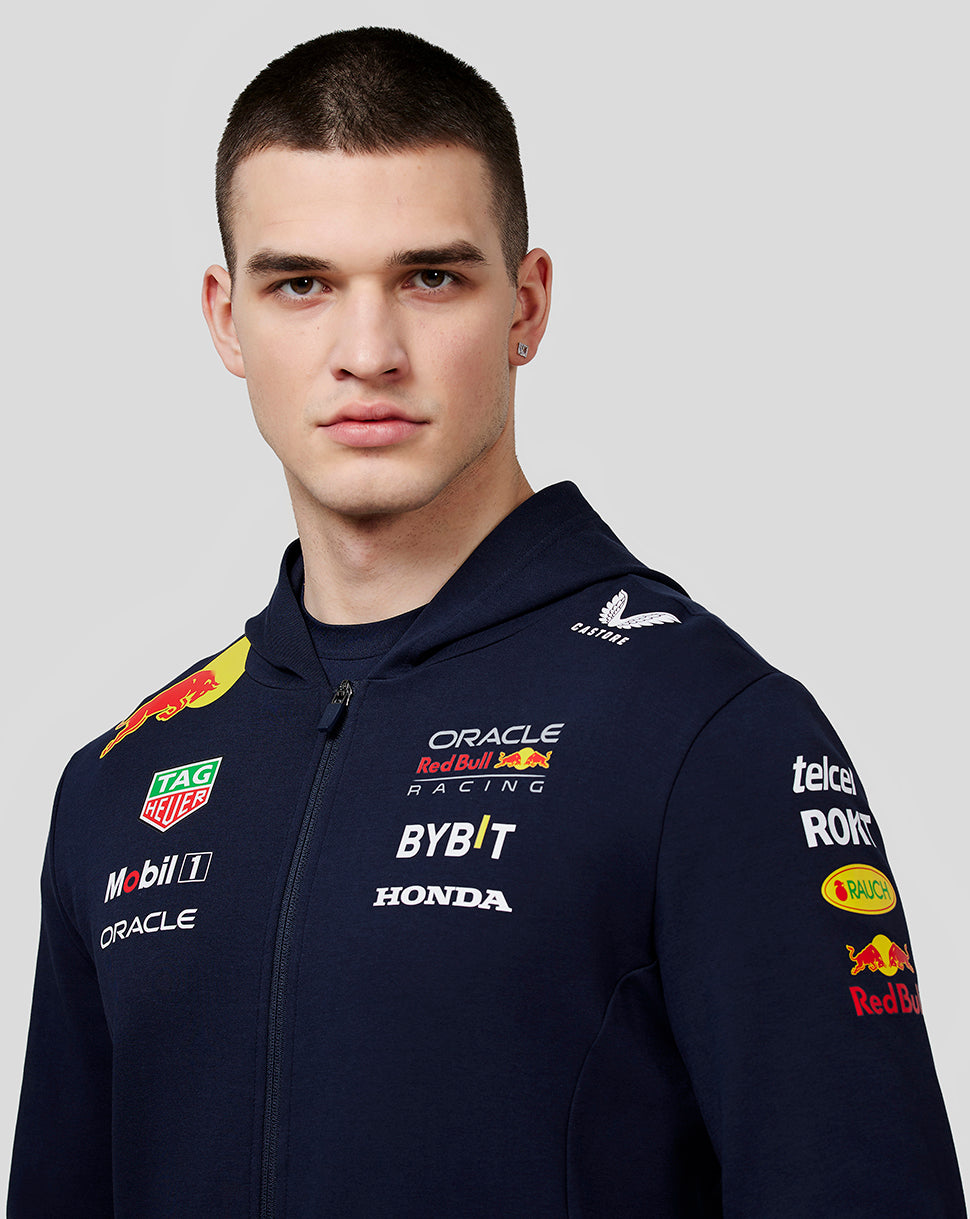 Male model wearing navy Oracle Red Bull Racing Teamline Full Zip Hoodie with sponsor logos on chest sleeves and back