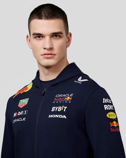 Male model wearing navy Oracle Red Bull Racing Teamline Full Zip Hoodie with sponsor logos on chest sleeves and back