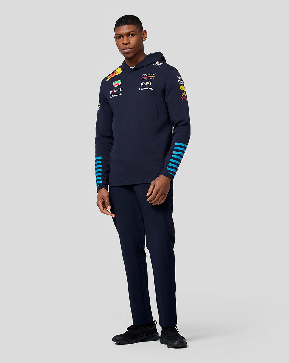 Front view of a man wearing a navy teamline hoodie with Oracle Red Bull Racing logos on the chest and blue stripe details on the sleeves