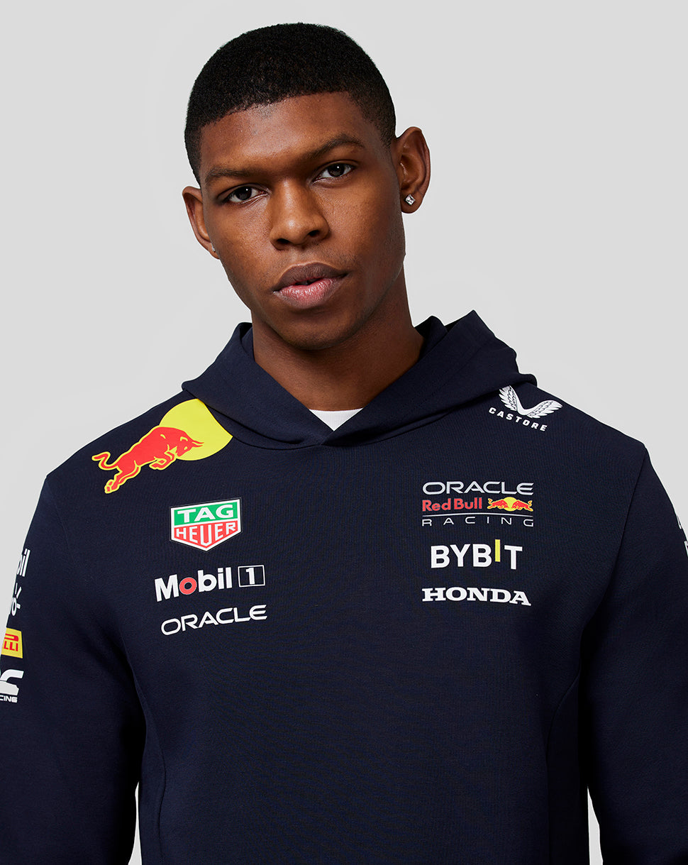 Close-up of a model in a navy Teamline hoodie showing chest sponsor logos and branding