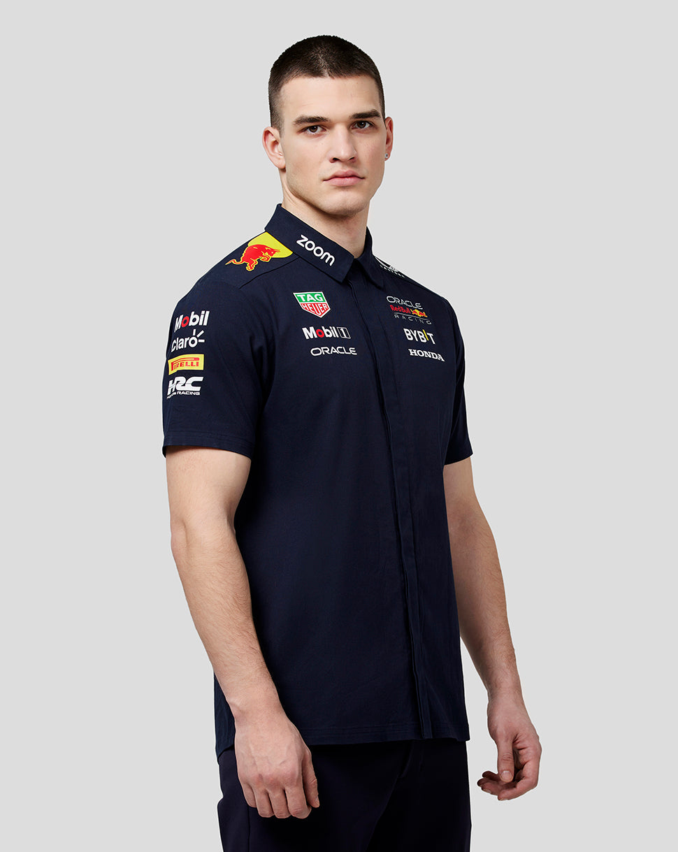 Model wearing a navy Oracle Red Bull Racing teamline short sleeve buttoned shirt with logos on chest and sleeves