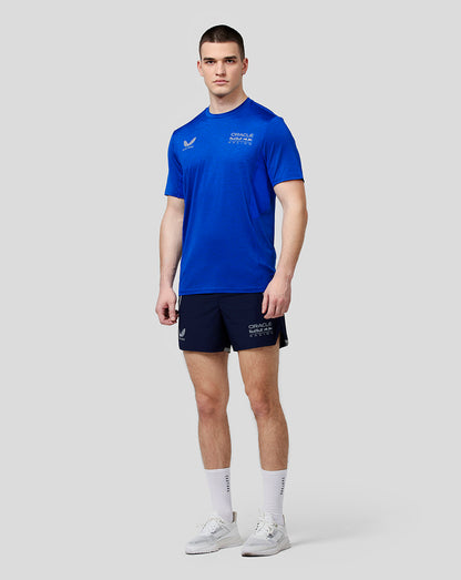 Full-body view of a model in blue Oracle Red Bull Racing tee and navy shorts with branding