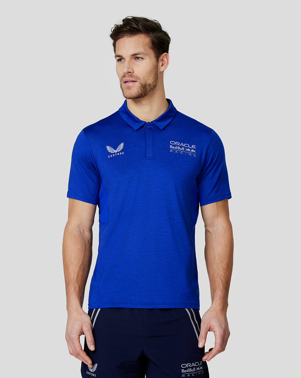 Male model wearing a blue Oracle Red Bull Racing polo with Castore wing logo on the chest