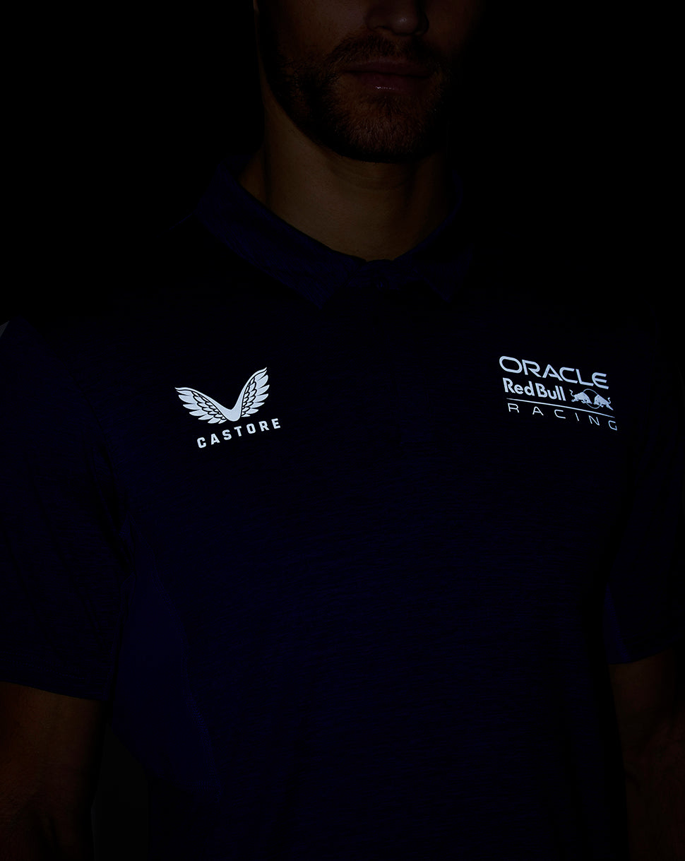 Man wearing a navy Oracle Red Bull Racing Castore polo with logos on the chest.