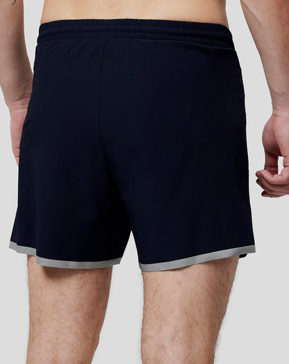 Back view of navy running shorts with elastic waistband and light grey hem trim.