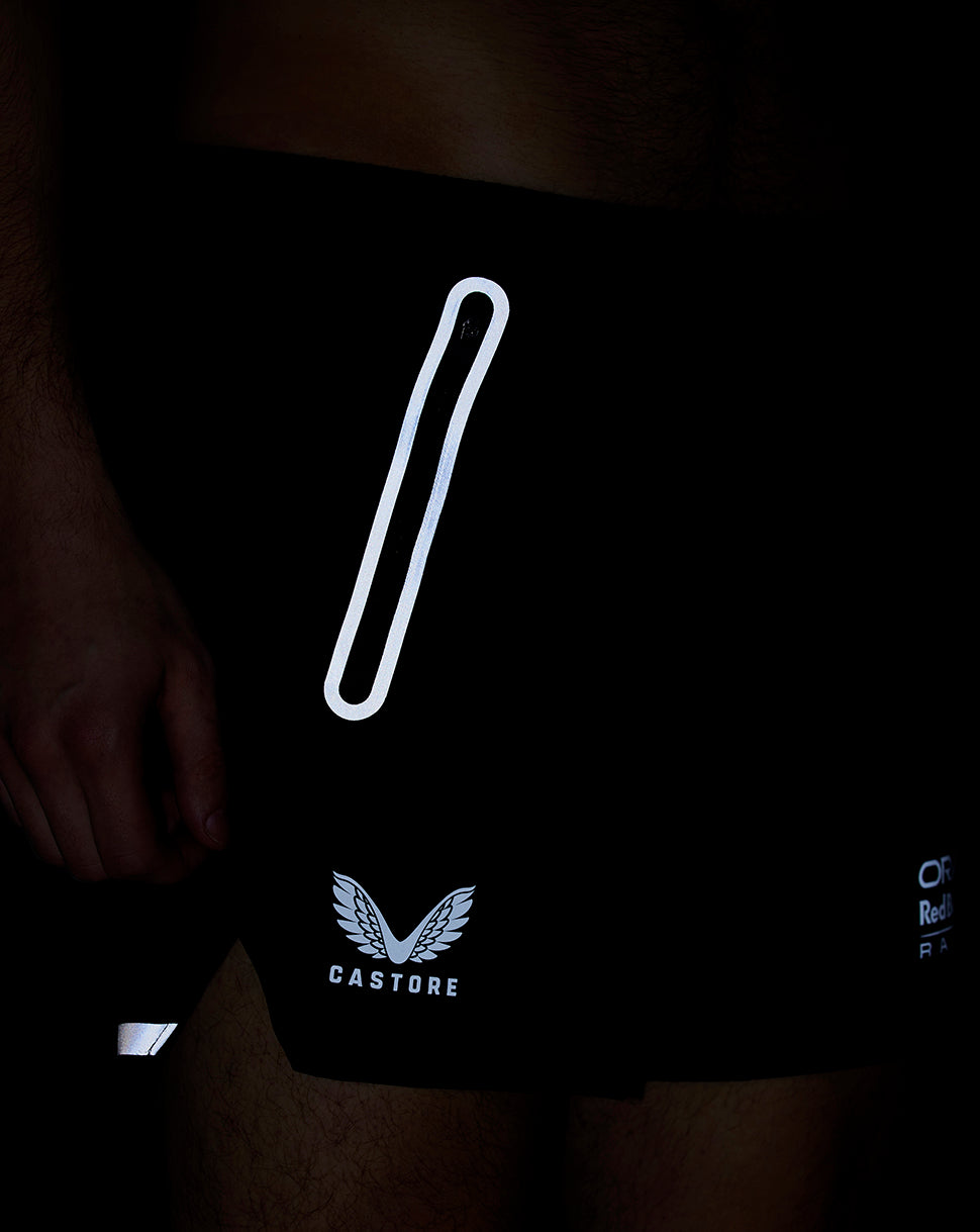Close-up of black Oracle Red Bull Racing shorts with a reflective vertical stripe and Castore logo