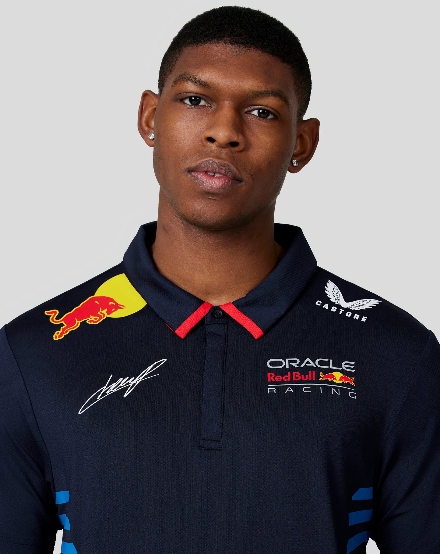 Close up of Night Sky navy polo chest showing Oracle Red Bull Racing crest and Red Bull badge with a signature.