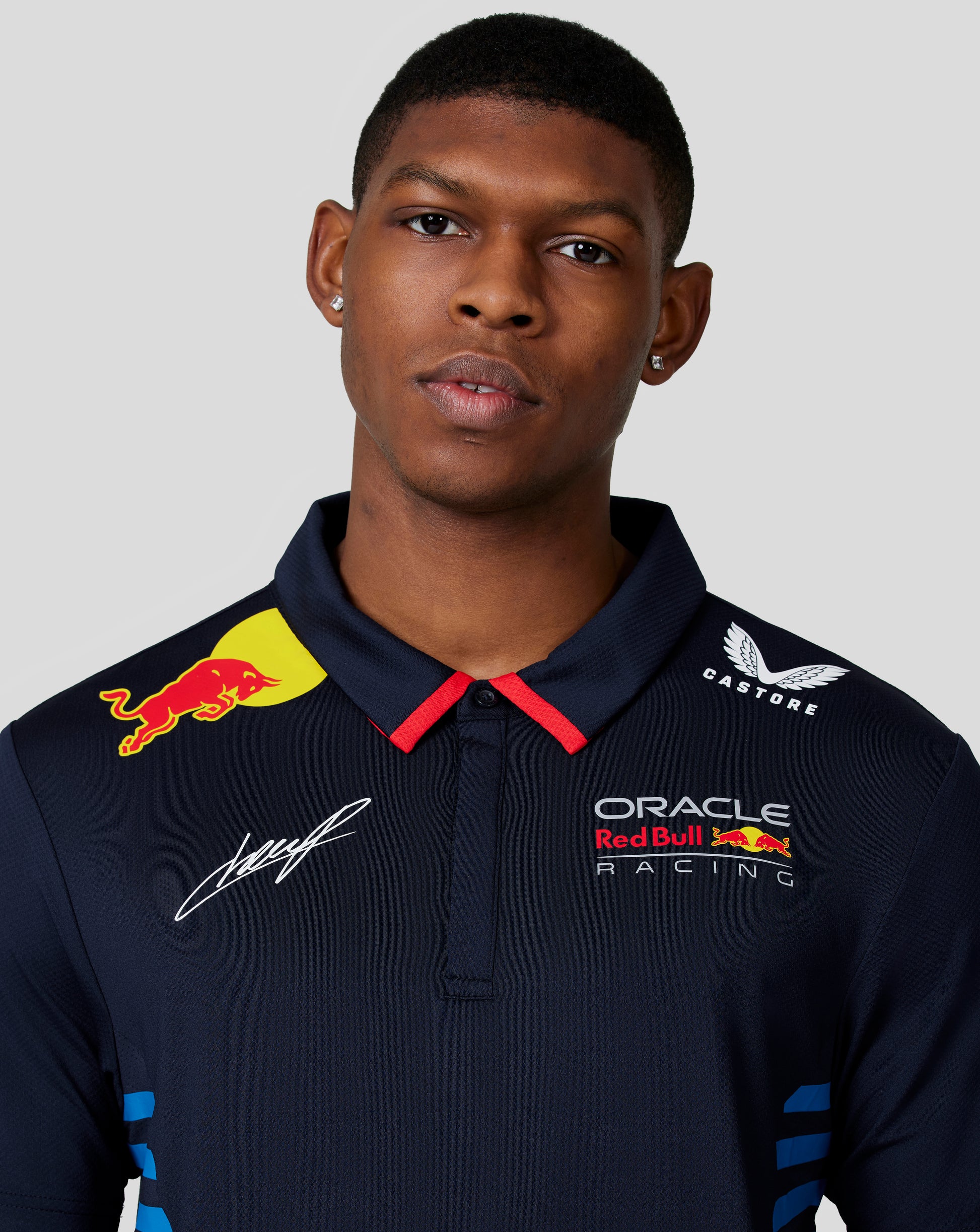 Close up of Night Sky navy polo chest showing Oracle Red Bull Racing crest and Red Bull badge with a signature.