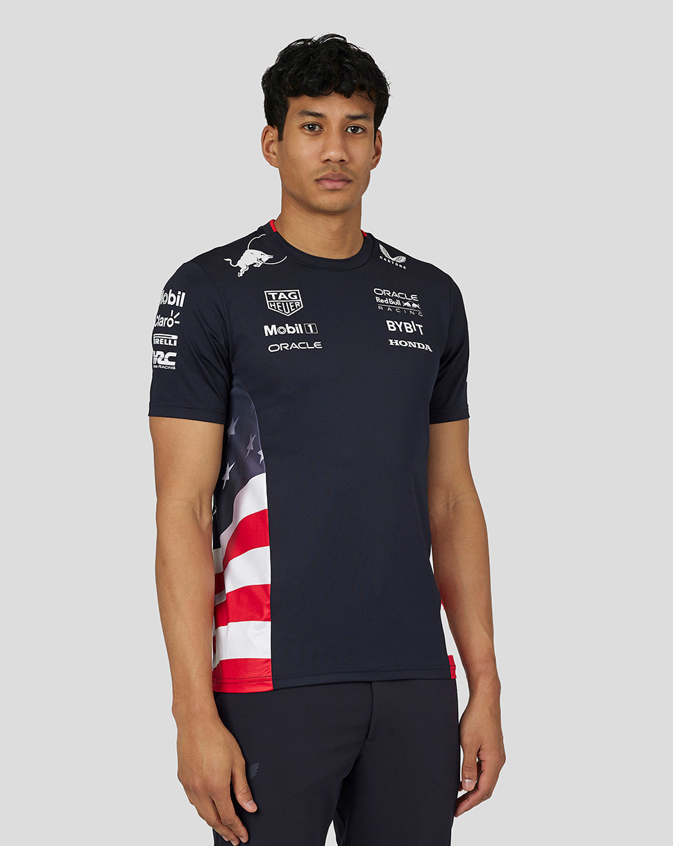 Man wearing a navy Oracle Red Bull Racing race team T shirt with sponsor logos and a US flag panel at the side
