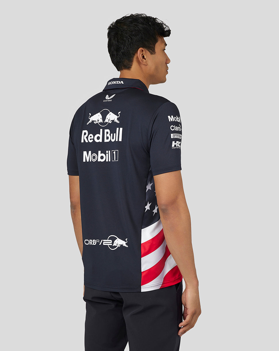 Back view of a man in a navy Night Sky Teamline polo showing large sponsor logos across the back.