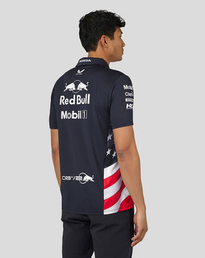 Back view of a man in a navy Night Sky Teamline polo showing large sponsor logos across the back.